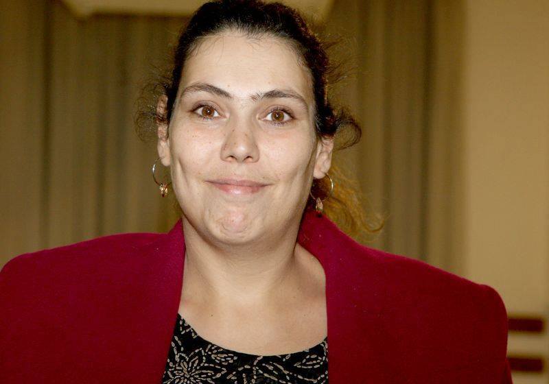 Ioana Tufaru zâmbitoare, cu părul prins, îmbrăcată în roșu și negru