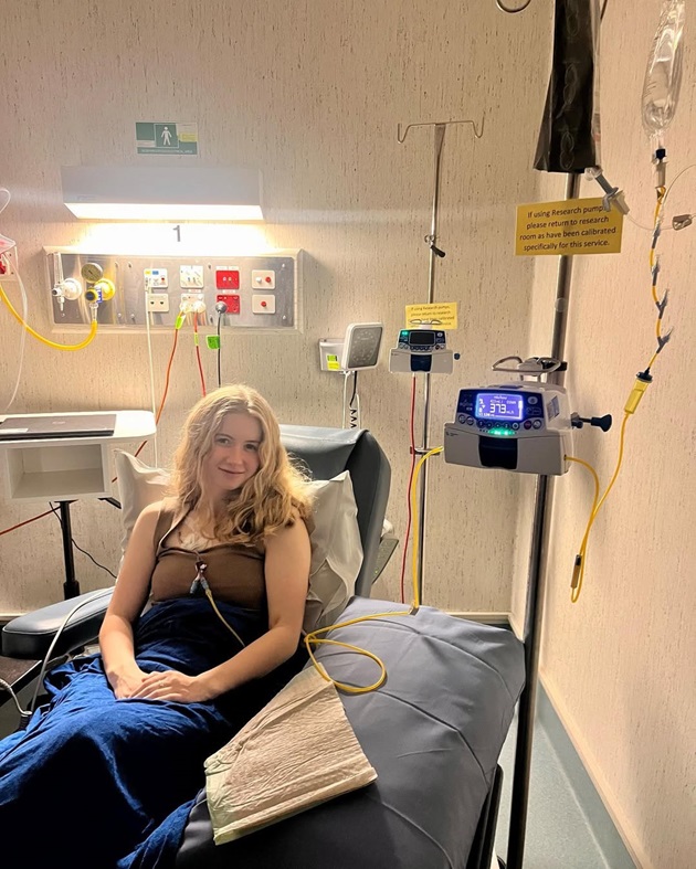 Dominique McShain pe patul de spital, în timpul unor investigații, în aprilie 2024, când a primit diagnosticul