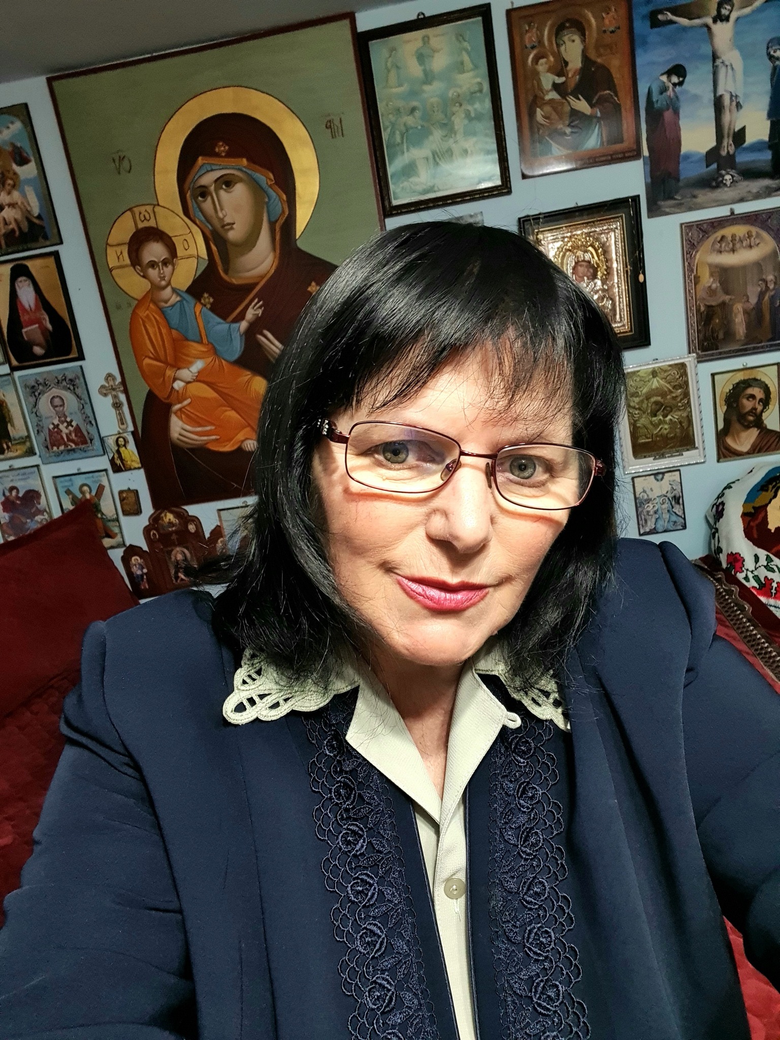 Clarvăzătoarea Maria Ghiorghiu făcându-și un selfie lângă un perete plin cu icoane