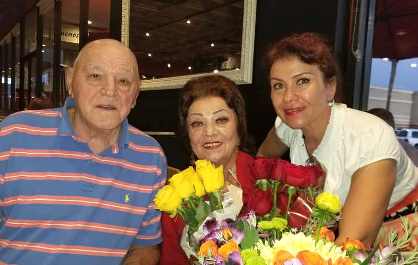 Mircea Câmpeanu și Camelia Ciobanu stând lângă Maria Ciobanu care are brațele pline cu flori
