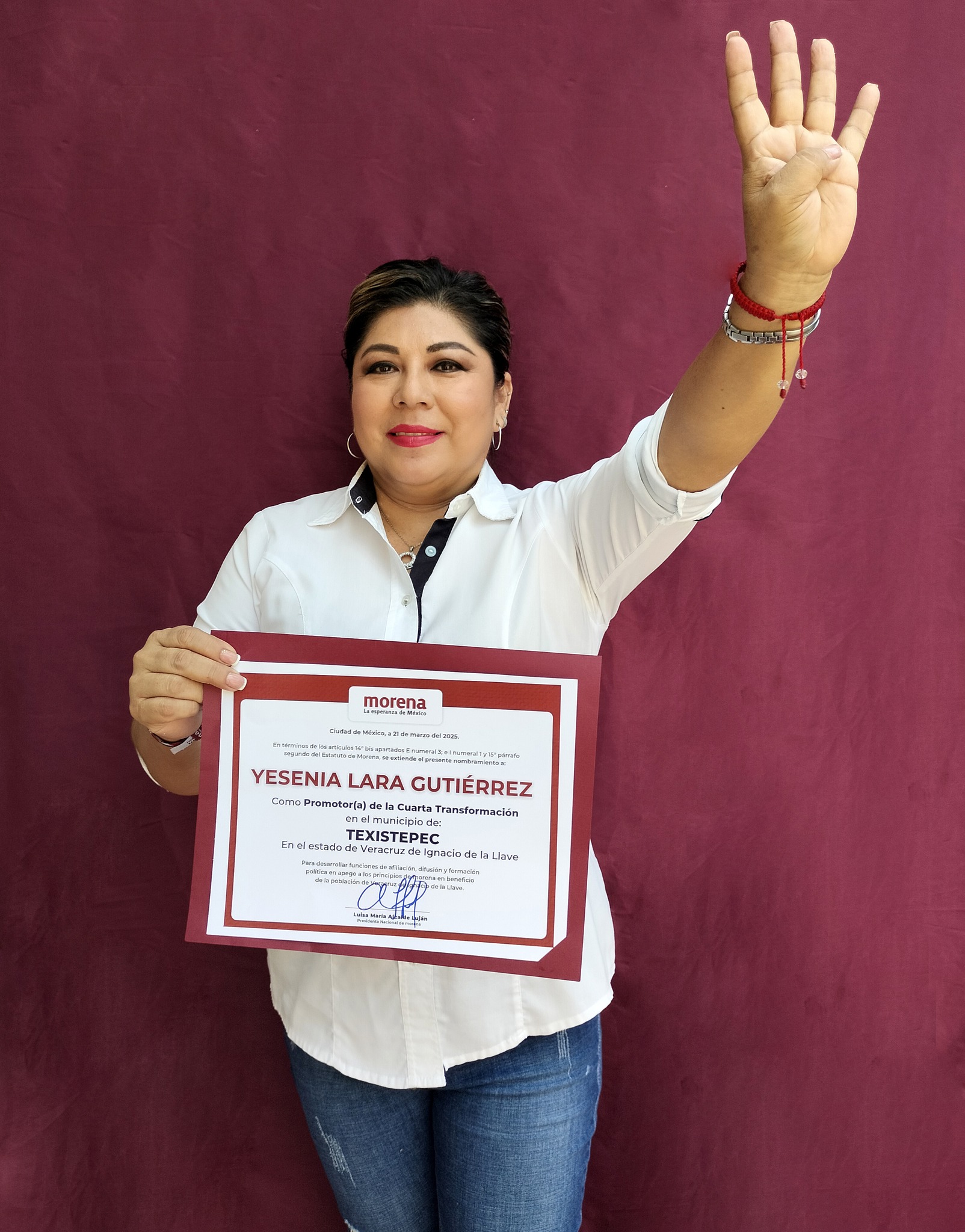 Yesenia Lara Gutiérrez îndemnând cetățenii să o voteze, îmbrăcată în blugi, cămașă albă și ținând o diplomă în mână
