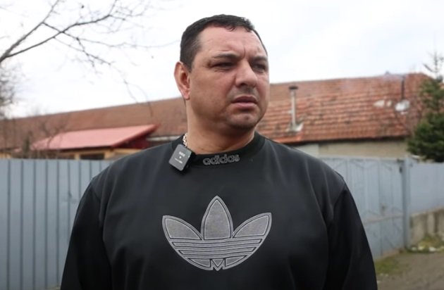 Fostul fotbalist Ionel Ganea îmbrăcat într-un tricou marca Adidas, în timpul unui interviu acordat pe stradă