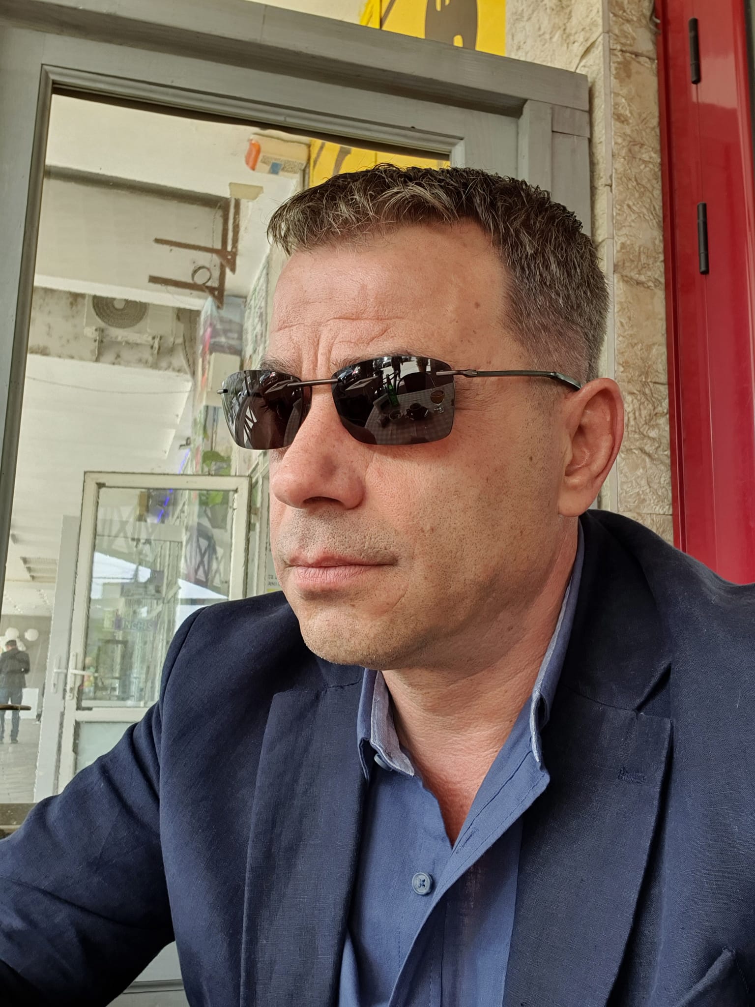 Robert Lupu, bărbatul care a ucis-o pe Teodora Marcu, îmbrăcat în cămașă și sacou, purtând ochelari de soare la ochi