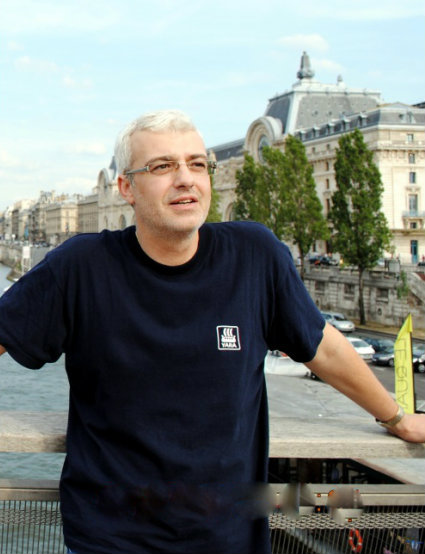 Cătălin Crișan stând pe terasa unei clădiri și admirând peisajul