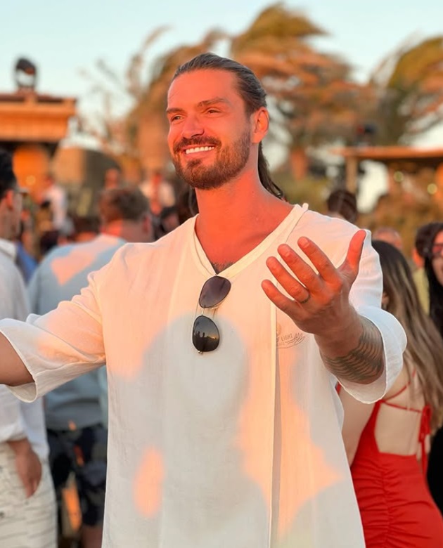 Bogdan Vlădău cu părul lung, prins în coadă, îmbrăcat într-o cămașă lungă de culoare albă, în timpul unuia dintre retreat-urile sale