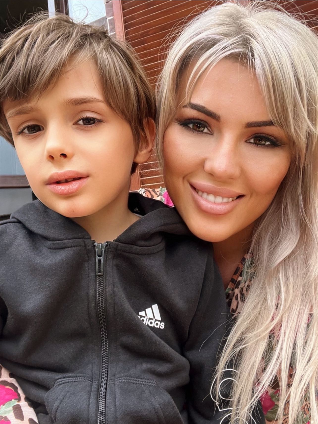 Iulia Sabbagh zâmbitoare, ținându-l în brațe pe fiul ei și al lui Christian Sabbagh