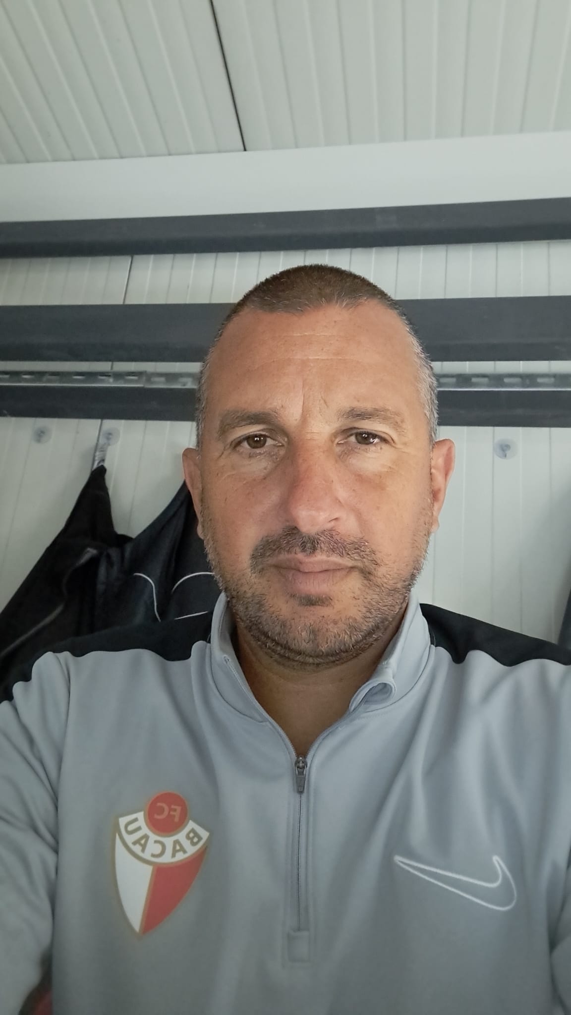 Costel Enache făcându-și un selfie în timp ce purta un hanorc ce are pe el sigla echipei pe care o antrenează - FC Bacău