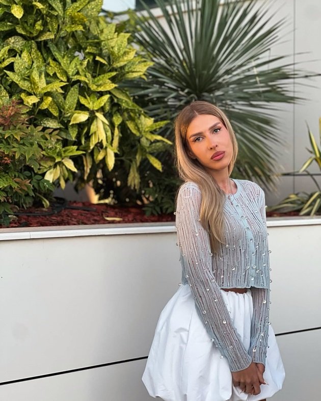 Make-up artista Raluca Jurca, logodnica lui Cezar Ouatu îmbrăcată într-o fustă scurtă, albă, și un top argintiu cu pietricele