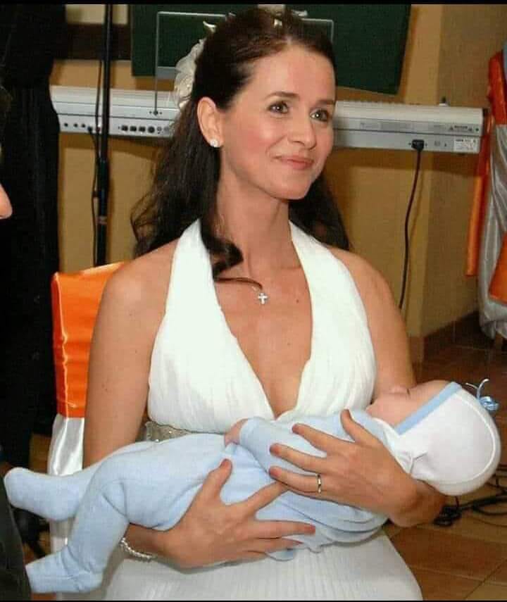 Mădălina Manole în ziua nunții sale, în rochie de mireasă, ținându-l în brațe pe fiul ei, care a fost botezat în aceeași zi