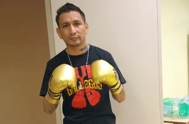 Pedro Antonio 'Tony' Rodriguez îmbrăcat în negru, purtând în mâini niște mănuși de box aurii și stând la poză într-o poziție de box