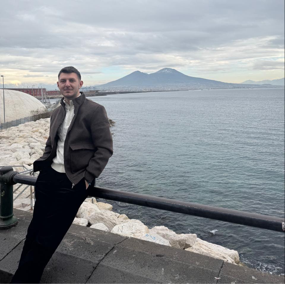 Florin Constantin Stoica, tânărul român stabilit în Italia, care vrea să-și întâlnească tatăl, pe malul mării, în Napoli, stând sprijinit de un gard de delimitare, cu mâinile în buzunar