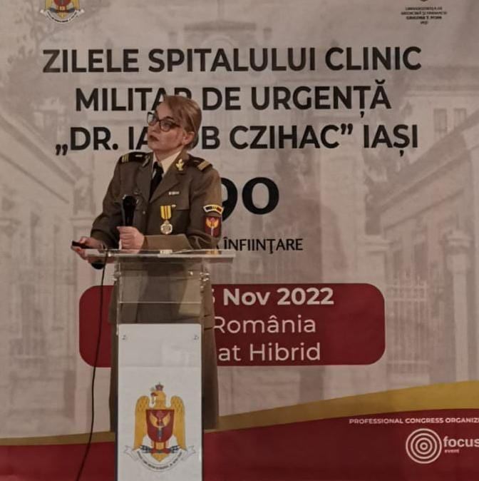 Dr. Sînziana Lovin în uniformă militară, vorbind în fața unui public la un eveniment, în 2022