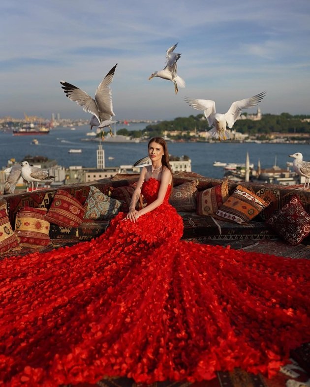 Teodora Marcu în timpul unei ședințe foto speciale în Turcia, îmbrăcată într-o rochie lungă, roșie.