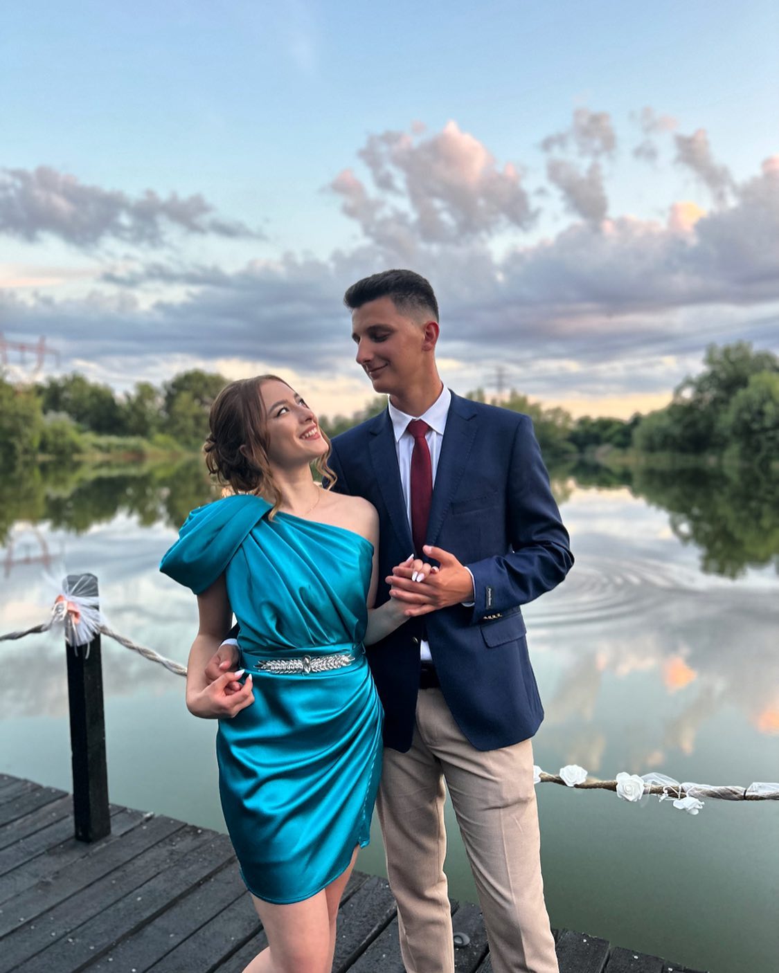 Ștefania Boteanu și Ștefan Berevoianu la un eveniment, îmbrăcați elegant, ea în rochie turcoaz, el în costum cu pantaloni crem și sacou albastru