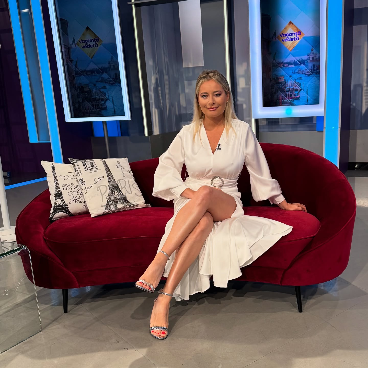 Laura Cosoi stând pe canapeaua din platoul emisiunii pe care o prezintă la Antena Stars