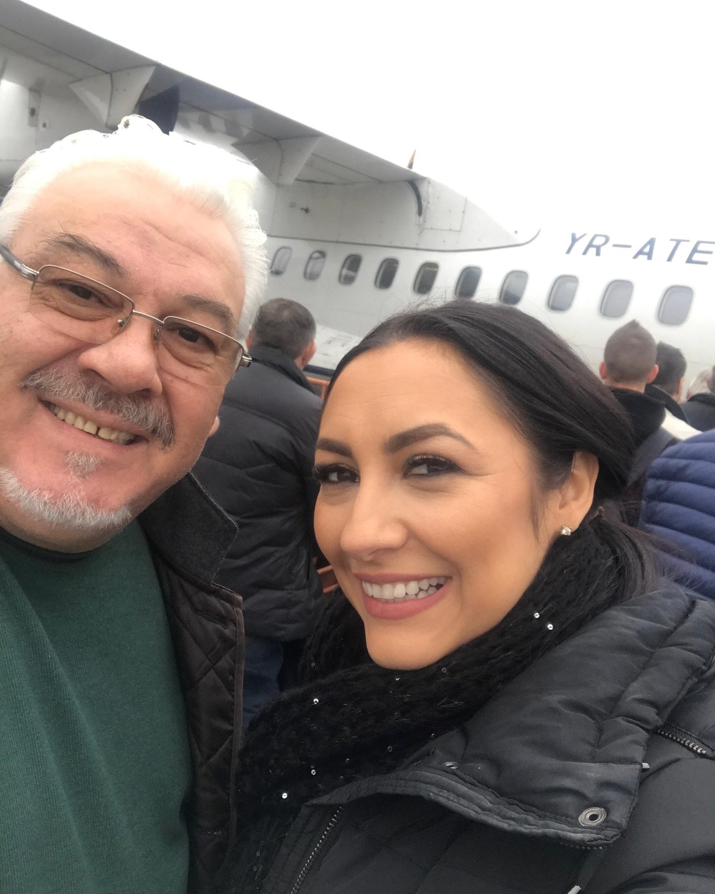 Andra zâmbitoare alături de tatăl ei, în aeroport, lângă un avion, înainte de îmbarcare