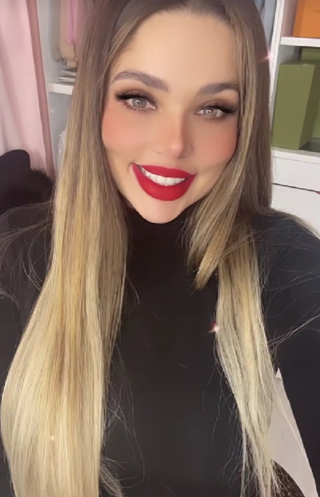 Esmeralda Ferrer Garibay zâmbitoare, cu părul lung și blond, cu ruj roșu pe buze, îmbrăcată în negru