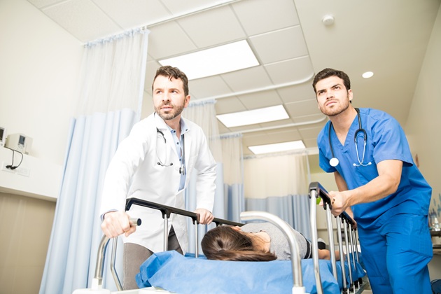 Cadre medicale care împing în grabă patul pe care se află o pacientă
