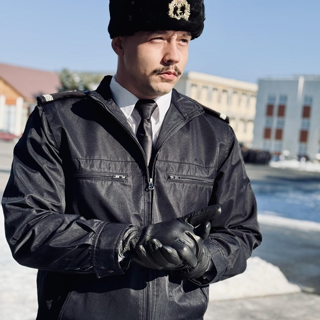 Cotescu Adelin Valentin în uniforma de la Academia Militară Navală din Constanța, cu mănuși de piele în mâini, ținându-și mâinile împreunate