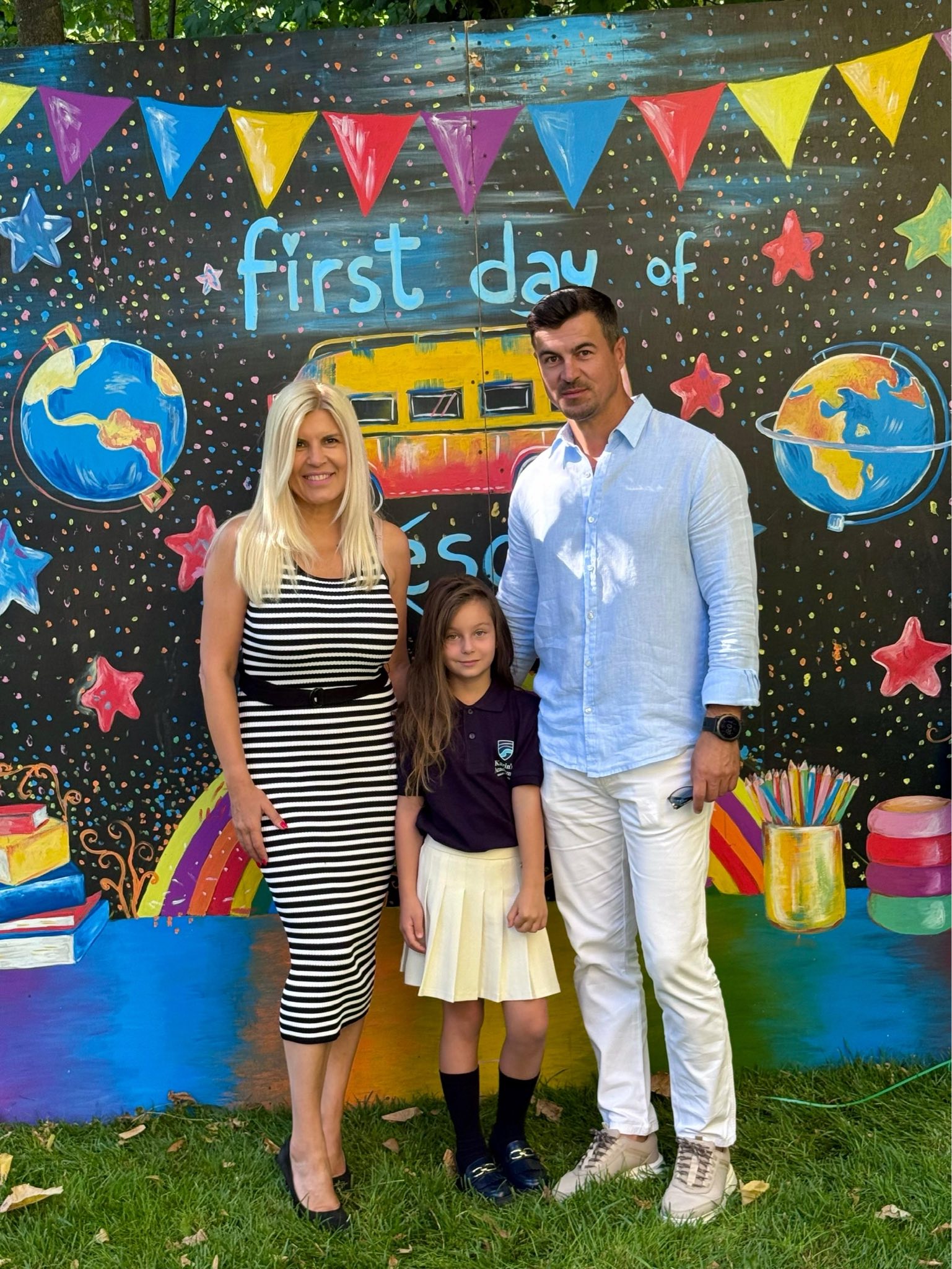 Elena Udrea și partenerul ei, Adrian Alexandrov, alături de fiica lor, Eva Maria, în prima zi de școală, făcându-ș poze la un panou care ilustrează începutul de an școlar