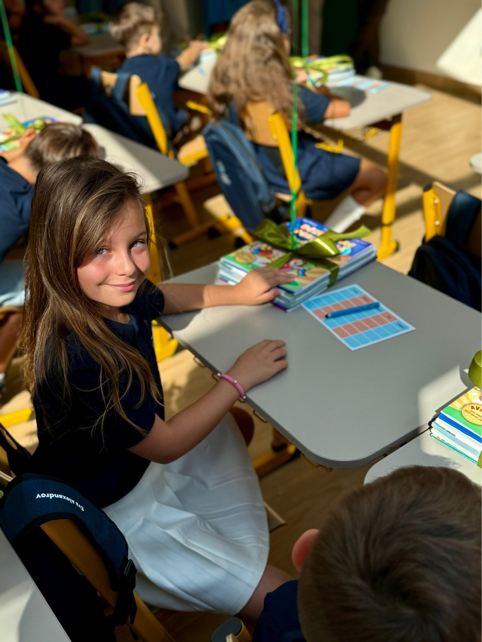 Eva Maria, fiica Elenei Udrea, stând în bancă, în clasă, în prima zi din anul școlar 2025-2026
