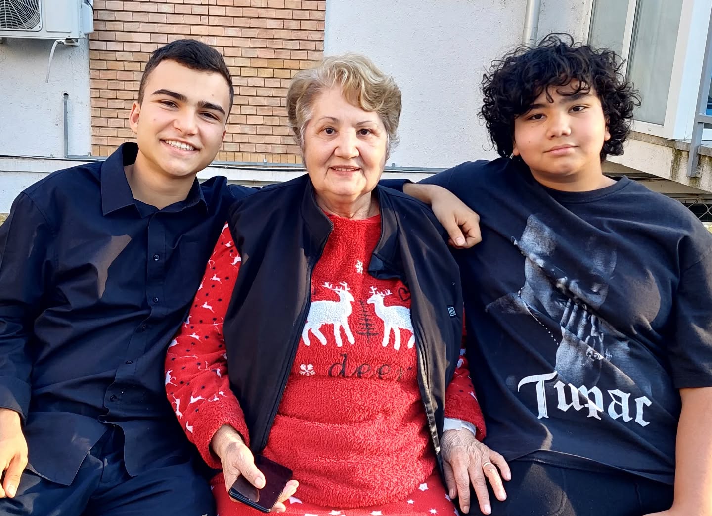 Petruța Toma în pijama roșie cu motive de Crăciun, alături de băieții Adrianei Bahmuțeanu, Maximus și Eduard, îmbrăcați în haine închise la culoare