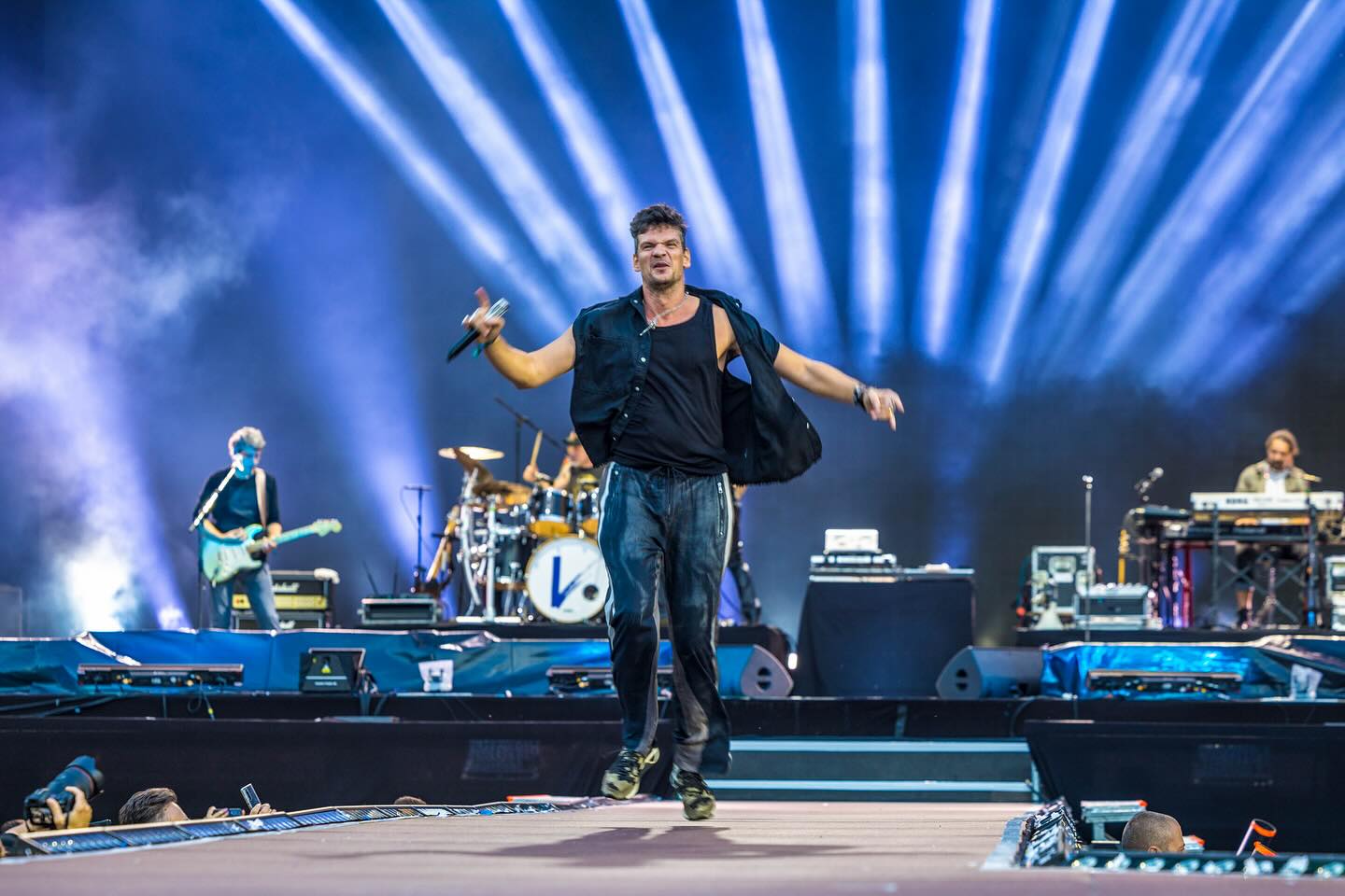 Tudor Chirilă pe scenă, în timpul unui concert, mergând spre marginea scenei pentru a se apropia de public