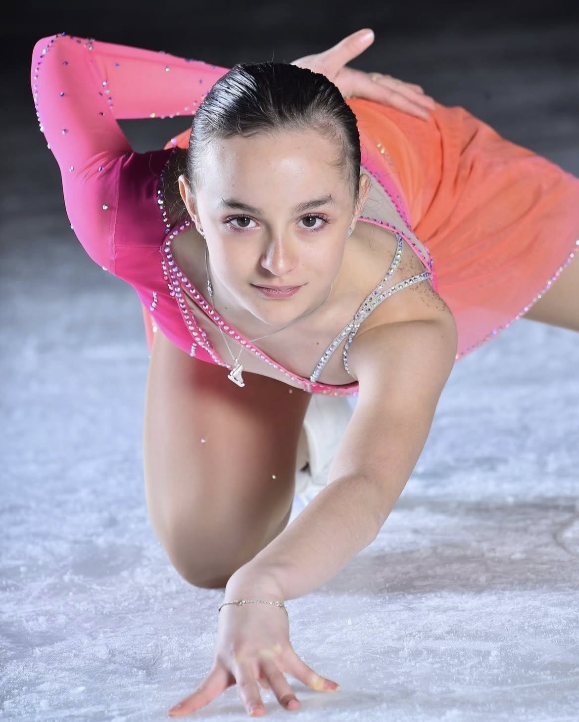 Patinatoarea Matilda Ferrari pe gheață, în costumul de patinaj în nuanțe de roz și portocaliu, cu pietricele strălucitoare