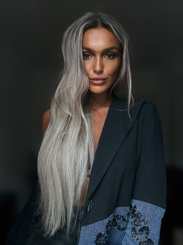 Ella Vișan cu părul lung, îndreptat, îmbrăcat într-un sacou negru cu inserții din denim
