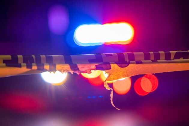 Fotografie făcută noaptea, la scurt timp după o tragedie, cu banda pusă de poliție pentru a putea cerceta zona, fără ca alte persoane să intre în perimetrul respectiv, cu lumina girofarului de poliție în fundal