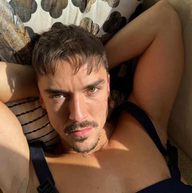 Emil Rengle în maiou negru, stând întins pe spate, cu mâinile încrucișate sub cap