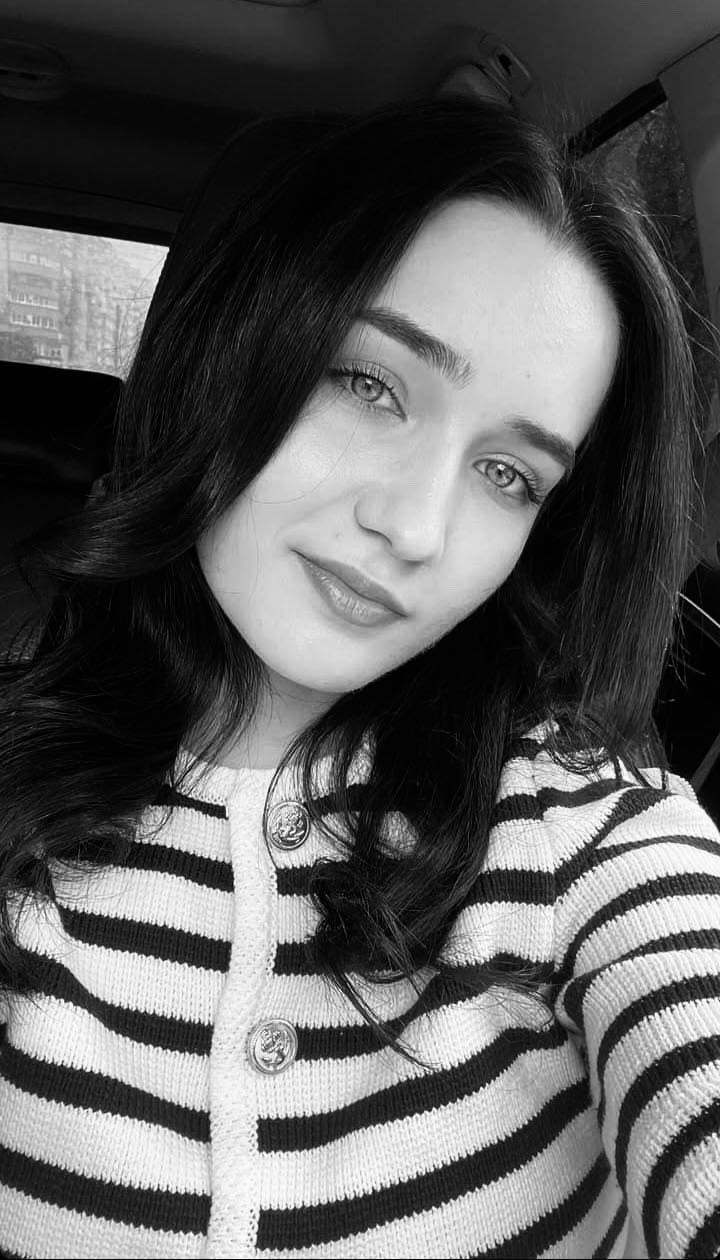 Imagine alb-negru cu Amalia Semeniuc făcându-și un selfie în mașină, îmbrăcată într-un pulover cu dungi albe și negre