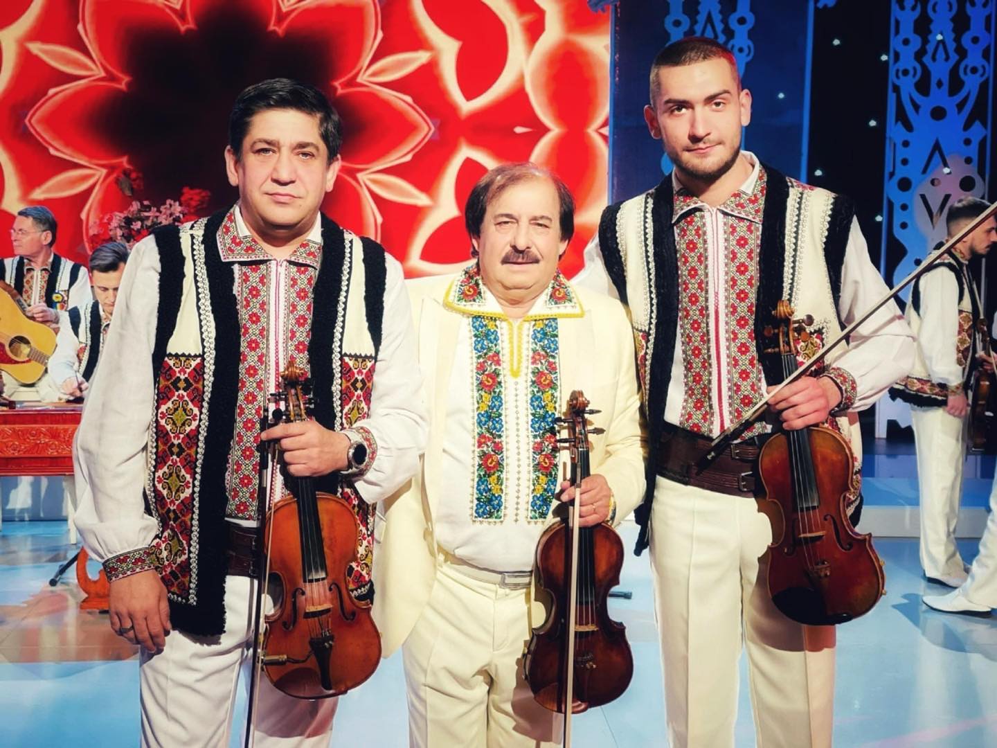 Cornel Botgros, Nicolae Botgros și Cristi Botgros în platoul unei emisiuni TV, îmbrăcați în costume populare, ținându-și viorile în mâini