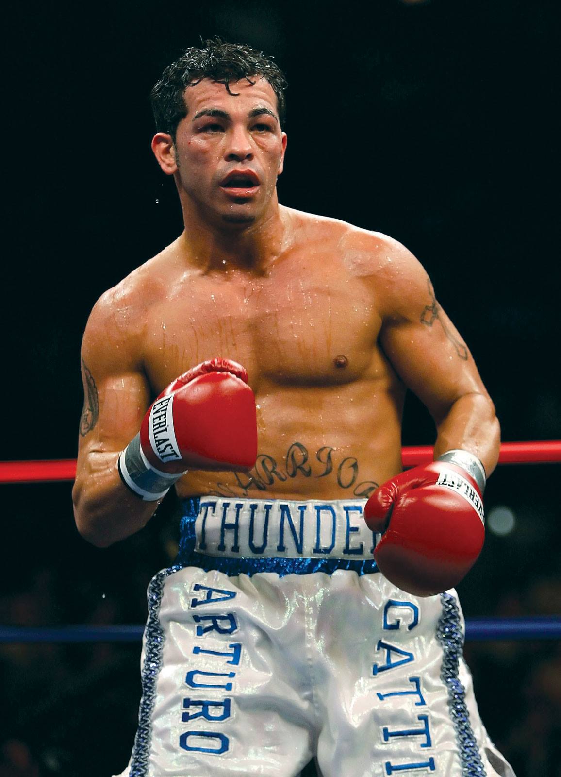 Arturo Gatti Sr. transpirat în ring, cu mănuși de box roșii în mâini, în timpul unui meci