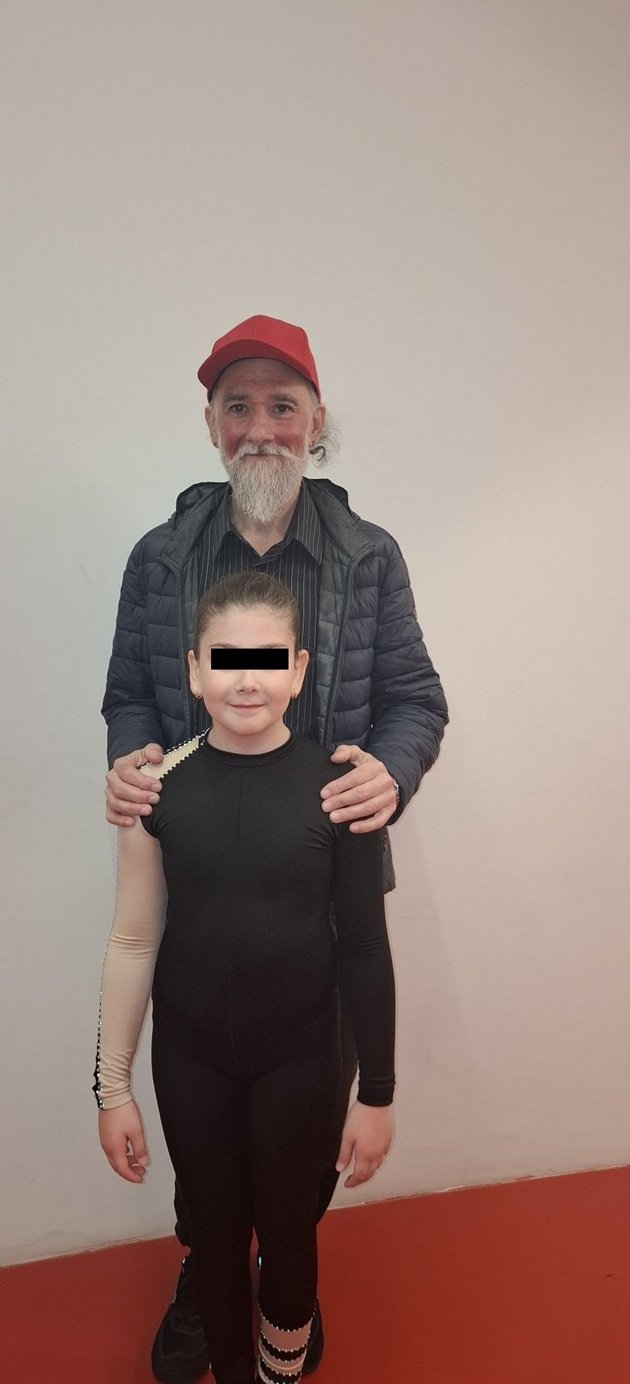 Marius Keseri ținând-o de umeri pe fiica sa, Ioana, îmbrăcată într-un costum negru de gimnastică