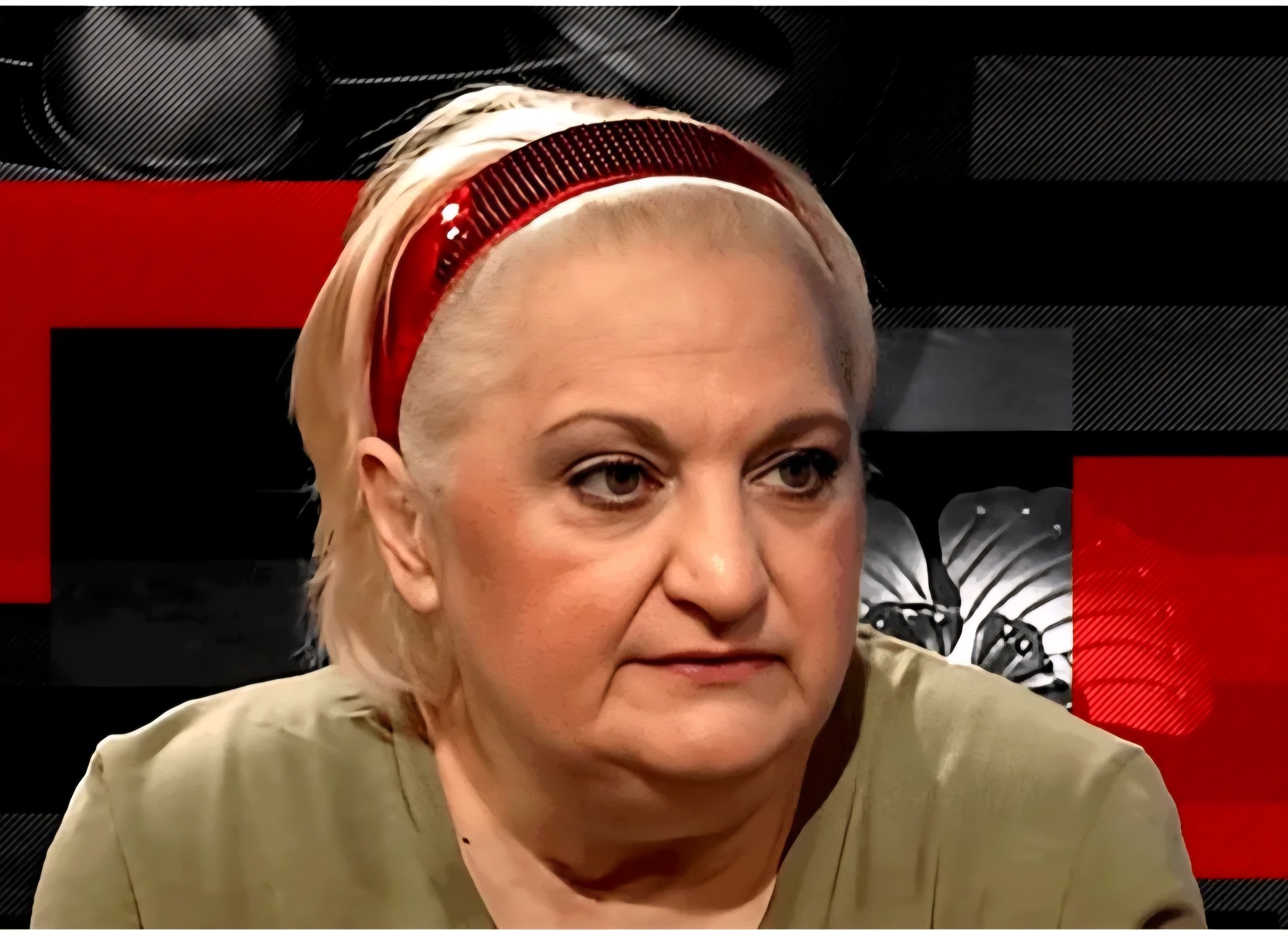 Marinela Chelaru îmbrăcată în verde, cu părul dat pe spate și ținut de o bentiță vișinie