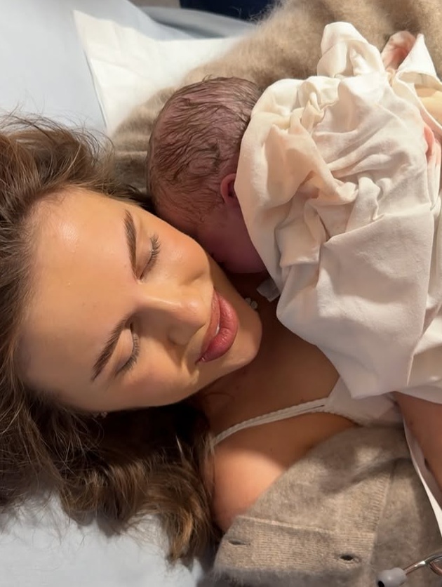 Emily Burghelea pe patul de spital, ținându-l pe piept pe bebelușul ei nou-născut