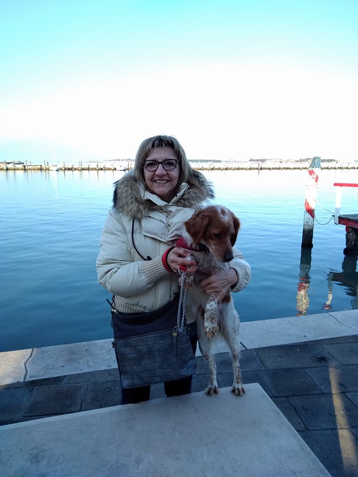 Aneta Filipov Mondin zâmbitoare, ținând în brațe un cățel