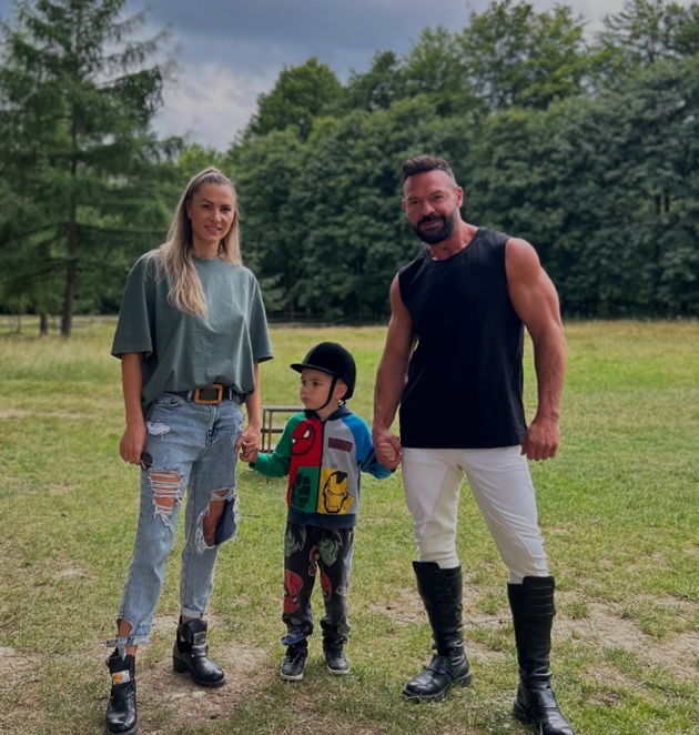 Bianca și Cornel Păsat alături de fiul lor, Dryas, ținându-se de mână, la o plimbare prin pădure, în timp ce micuțul are o cască de echitație pe cap