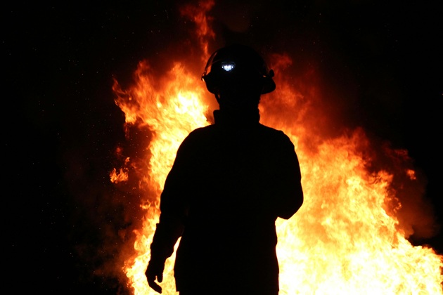 Pompier care încearcă să stingă un foc violent