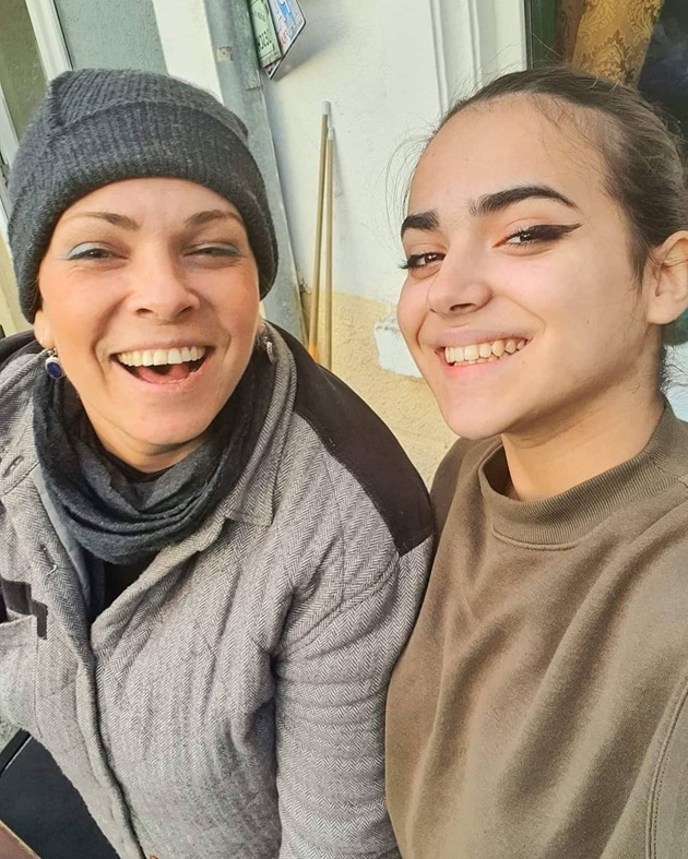 Dana Marijuana râzând, îmbrăcată gros, purtând căciulă, alături de Alesia, fiica ei cea mare, care zâmbește în timp ce face poza