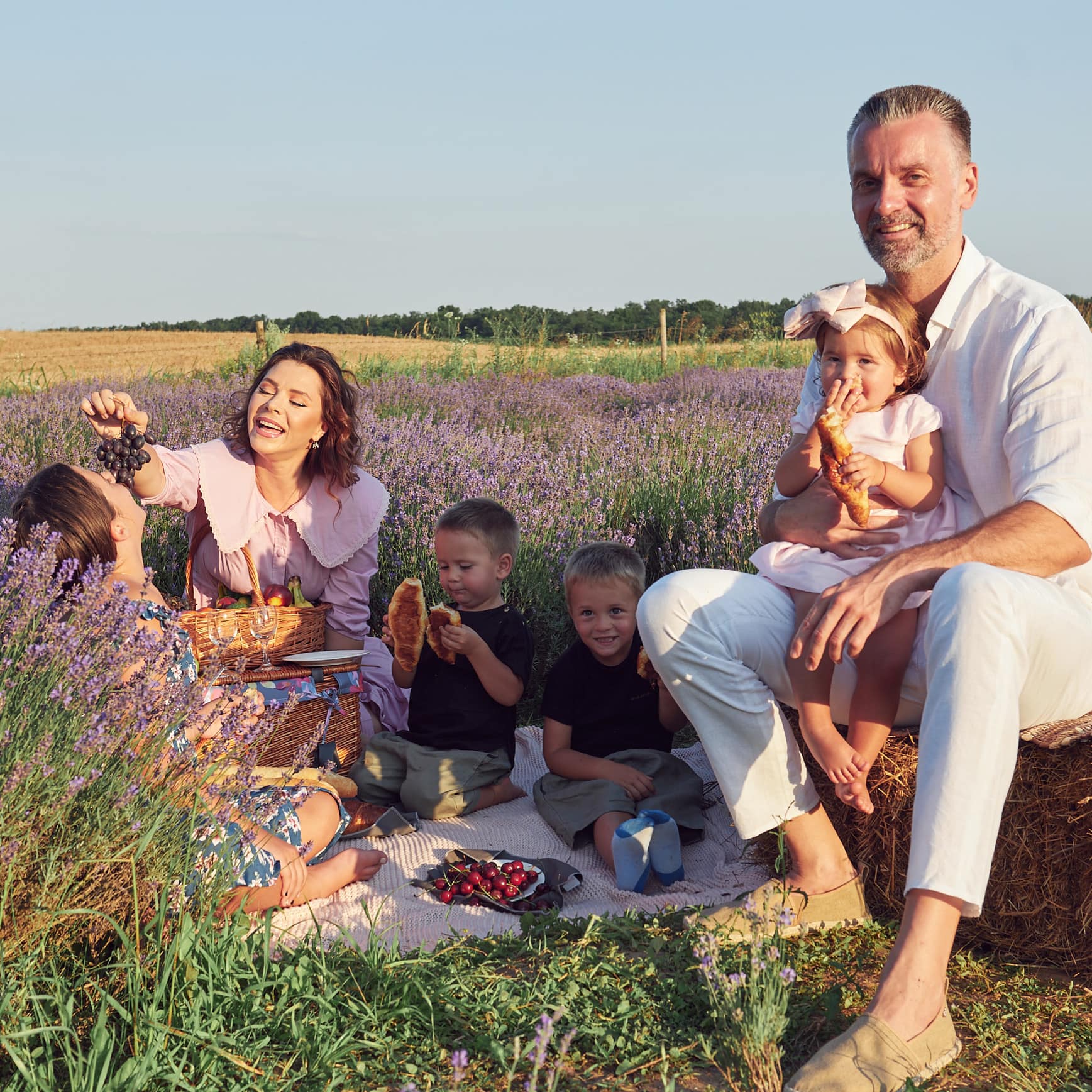 Oksana și Cezar Ionașcu la picnic într-un câmp de lavandă, alături de patru dintre copiii lor, doi băieți și două fete