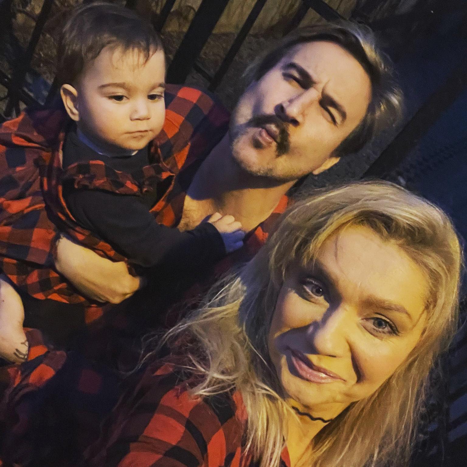 Cristina Cioran zâmbitoare în compania lui Alex Dobrescu care o ține în brațe pe fetița lor, Ema, la o plimbare pentru care s-au îmbrăcat toți trei asortat