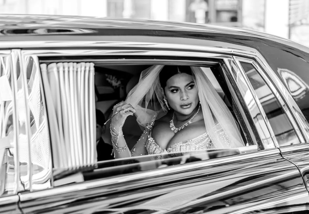 Imagine alb-negru cu Roxana Dobre, a doua soție a lui Florin Salam, în mașină, în rochie de mireasă și cu voal pe cap, în ziua nunții ei cu manelistul