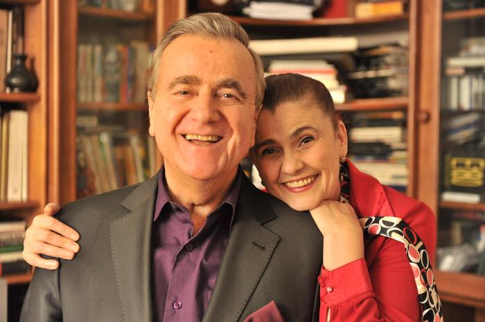 Soprana Felicia Filip zâmbitoare, în bibliotecă, sprijinindu-se de umărul soțului ei, regizorul Cristian Mihăilescu