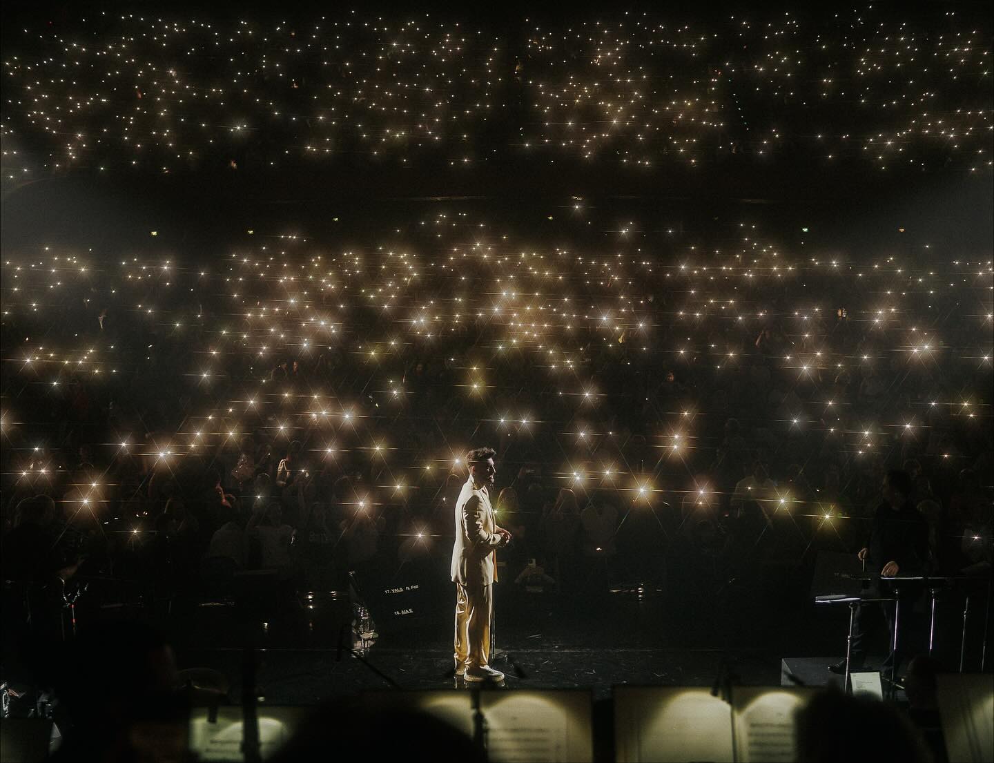 Smiley pe scena de la Sala Palatului, într-un costum galben, cântând în timp ce oamenii din public își țineau luminile de la telefon aprinse