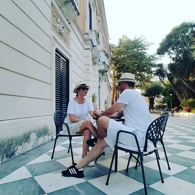 Andreea Marin și Adrian Brîncoveanu îmbrăcați în alb, stând la aceeași masă și privindu-se în ochi