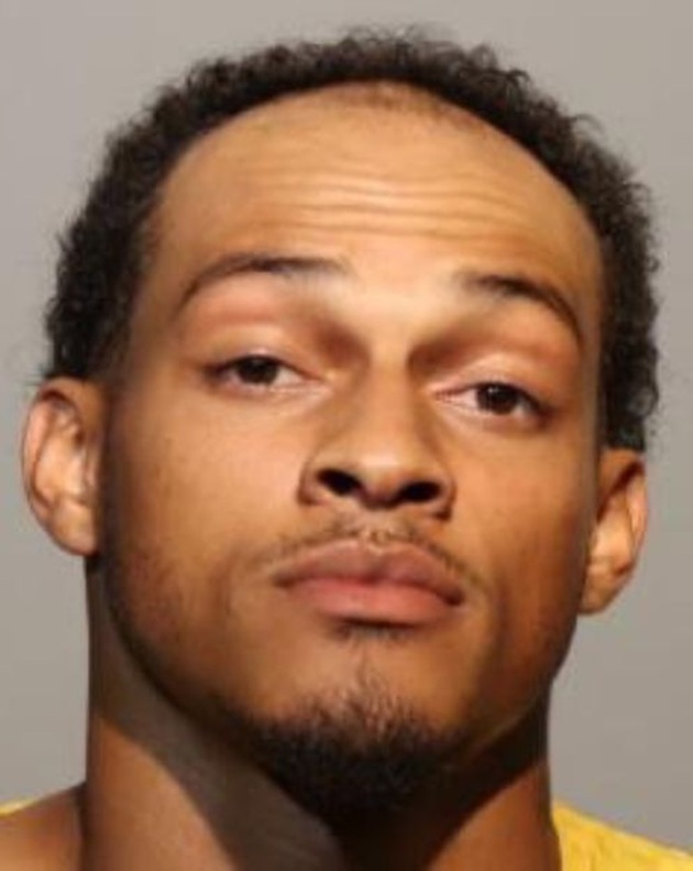 Portretul lui Donovan Faison, stând serios, îmbrăcat în galben