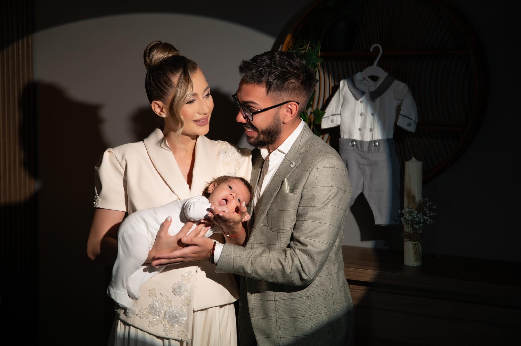 Armin Nicoară și Claudia Puican alături de fiul lor, Amir Efrem, îmbrăcați elegant, în ziua în care l-au botezat pe micuț