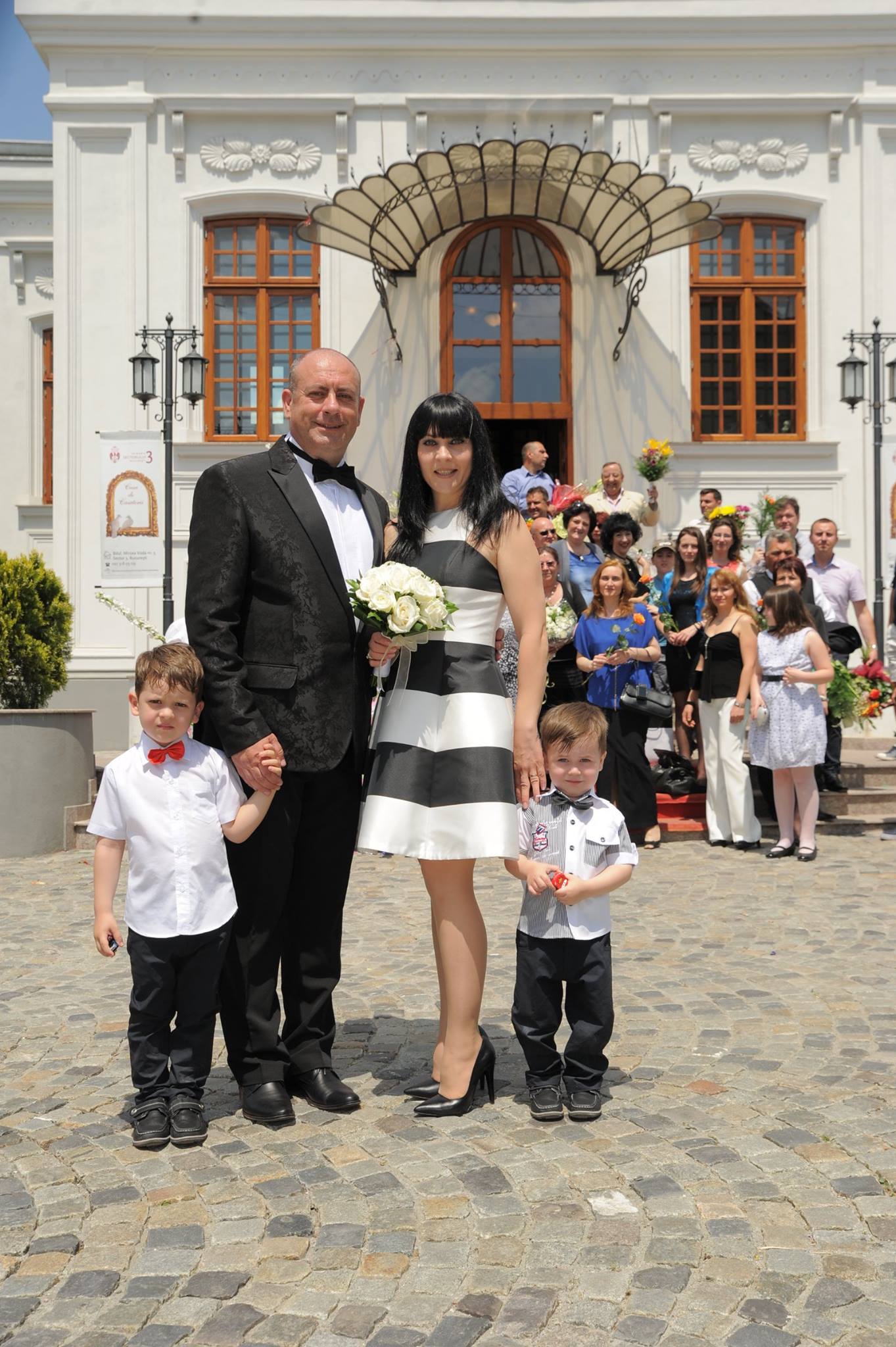 Emil Mitrache și soția sa, Cristina, îmbrăcați în alb și negru, alături de copiii lor, la starea civilă, în ziua în care s-au căsătorit civil
